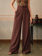 Pantalon large marron pour femme, taille haute, élégant, avec poches, porté avec un haut sans manches à motifs, style chic et moderne.