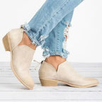 Bottines beiges en daim avec talons bas, portées avec un jean déchiré bleu clair. Chaussures tendance pour femme, style décontracté et moderne.