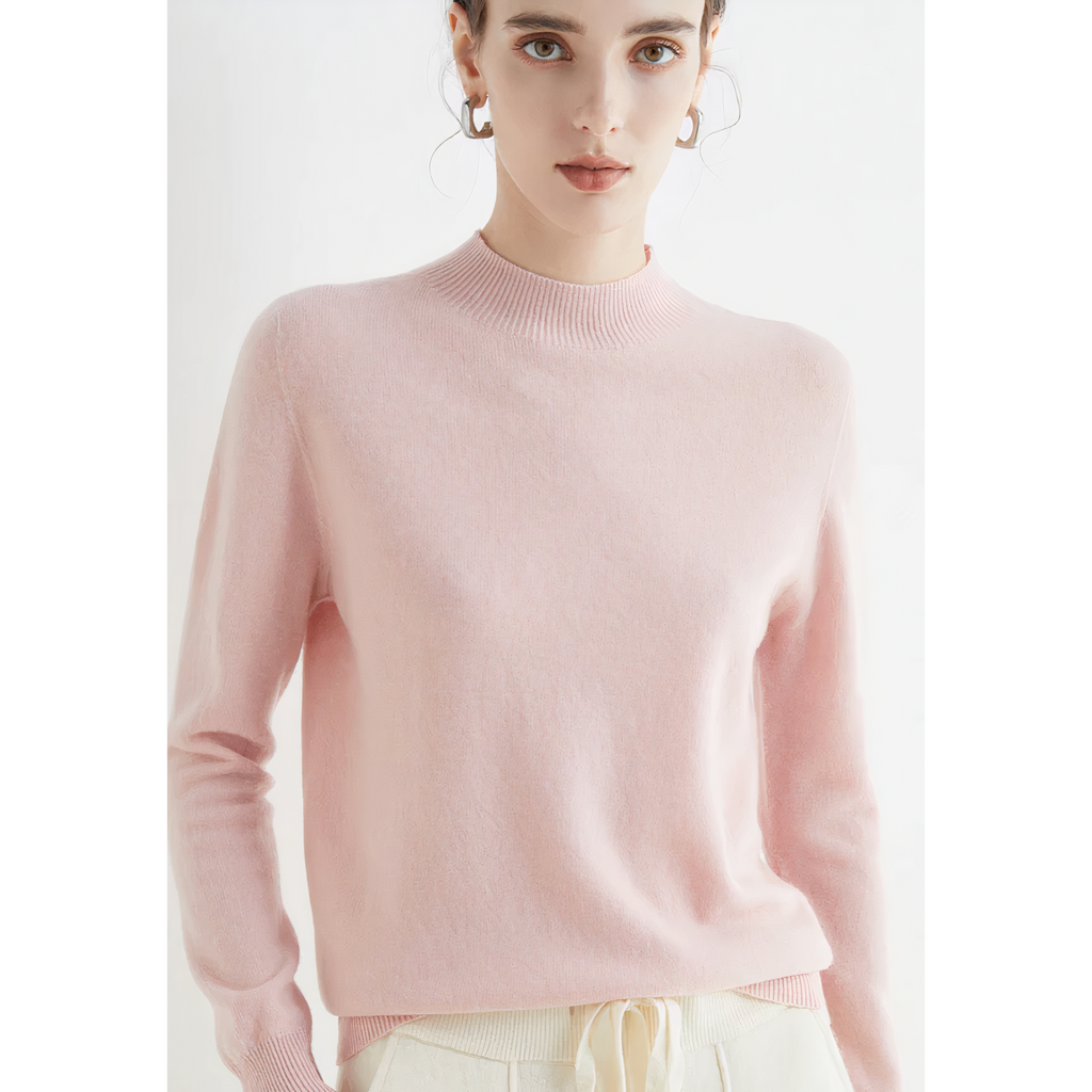 Femme portant un pull rose en cachemire, manches longues, col rond, avec des boucles d'oreilles dorées. Mode féminine élégante et confortable.