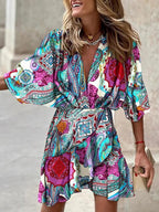 Robe bohème colorée à motifs paisley, manches larges, portée par une femme souriante. Mode estivale, style décontracté et tendance.