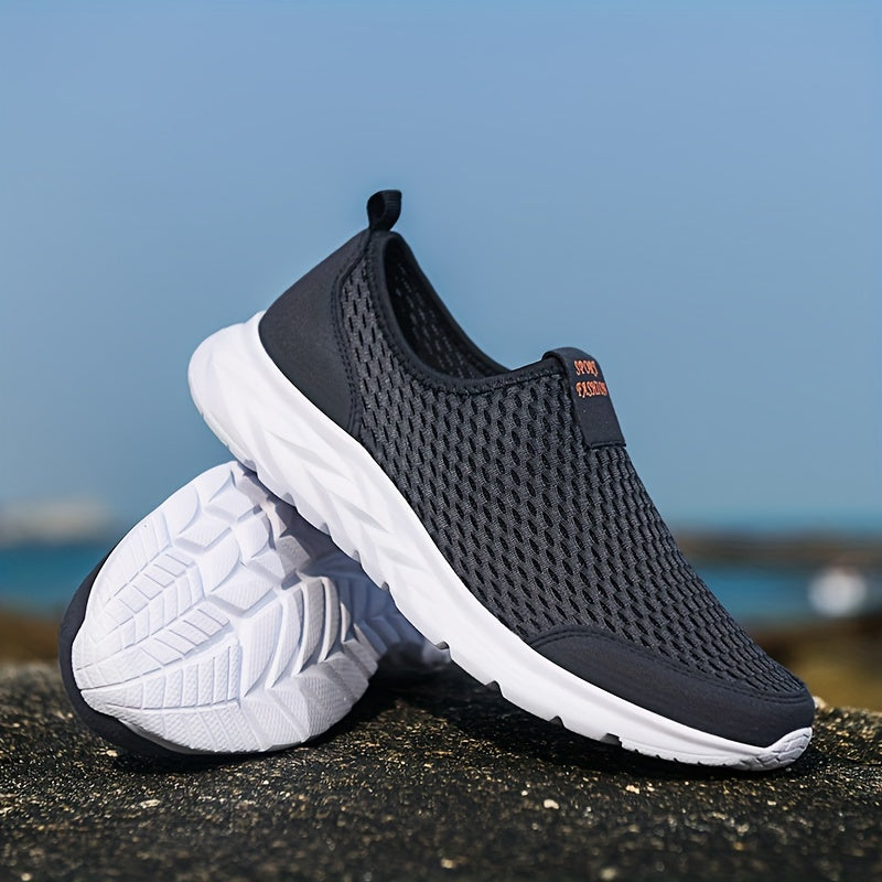 Chaussures de sport noires en maille respirante avec semelles blanches, posées sur un rocher, idéales pour la course et le fitness en plein air.