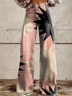 Jean évasé femme avec motif géométrique coloré, taille haute, style vintage, fond mural texturé, mode automne, tendance années 70.