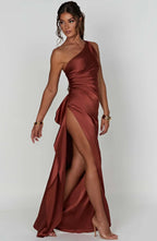 Robe de soirée asymétrique marron, fendue, portée par une femme. Élégante et moderne, idéale pour événements formels et soirées glamour.