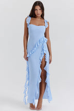 Robe longue bleue à volants, fente latérale, portée par une femme. Mode élégante, tenue de soirée, style chic et tendance.