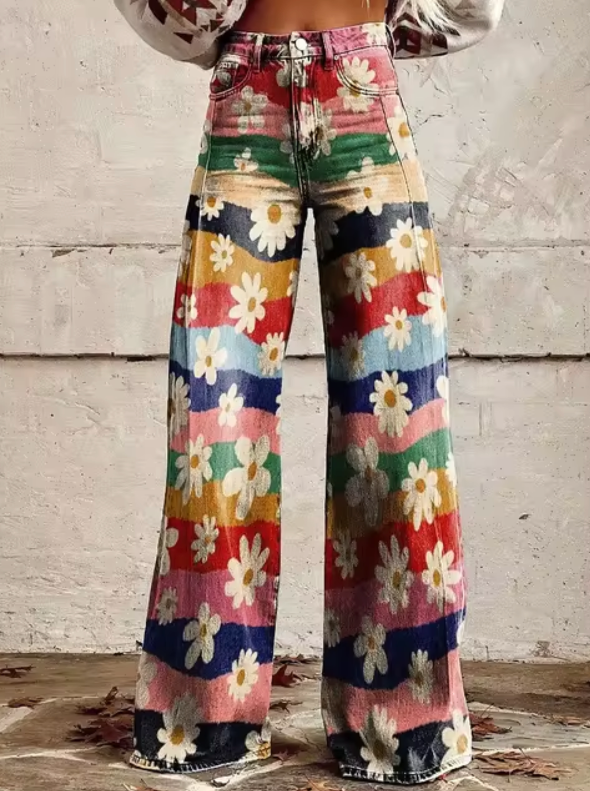 Pantalon évasé à motifs floraux multicolores, style vintage années 70, avec fleurs blanches et rayures colorées, mode rétro tendance.