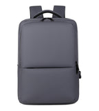 Sac à dos gris moderne et minimaliste, avec bretelles rembourrées, poche avant zippée, idéal pour ordinateur portable et usage quotidien.