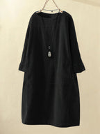Robe noire en velours côtelé, manches longues, coupe ample, avec collier pendentif. Mode élégante, style décontracté, vêtement automne-hiver.