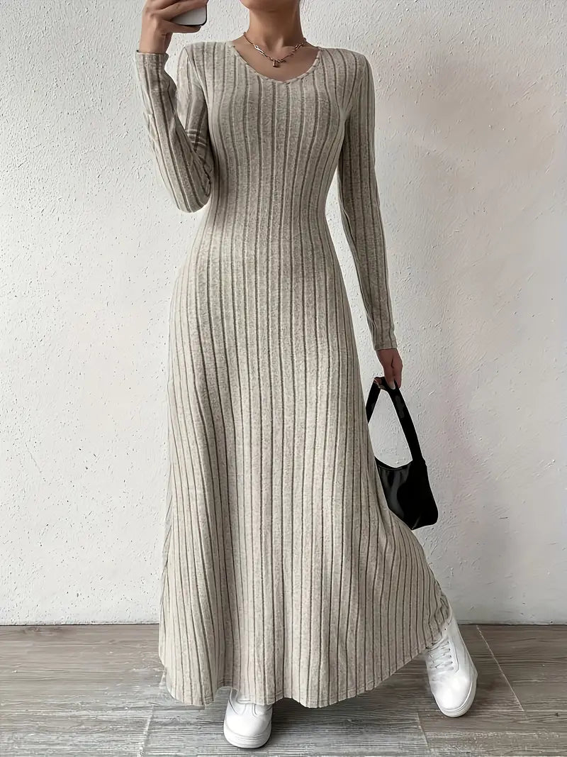 Robe longue en maille côtelée beige, manches longues, portée avec des baskets blanches et un sac noir. Mode féminine élégante et décontractée.