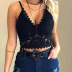 Femme portant un haut en dentelle noire, style crop top, avec jeans déchirés et ceinture noire. Mode féminine tendance, tenue décontractée chic.