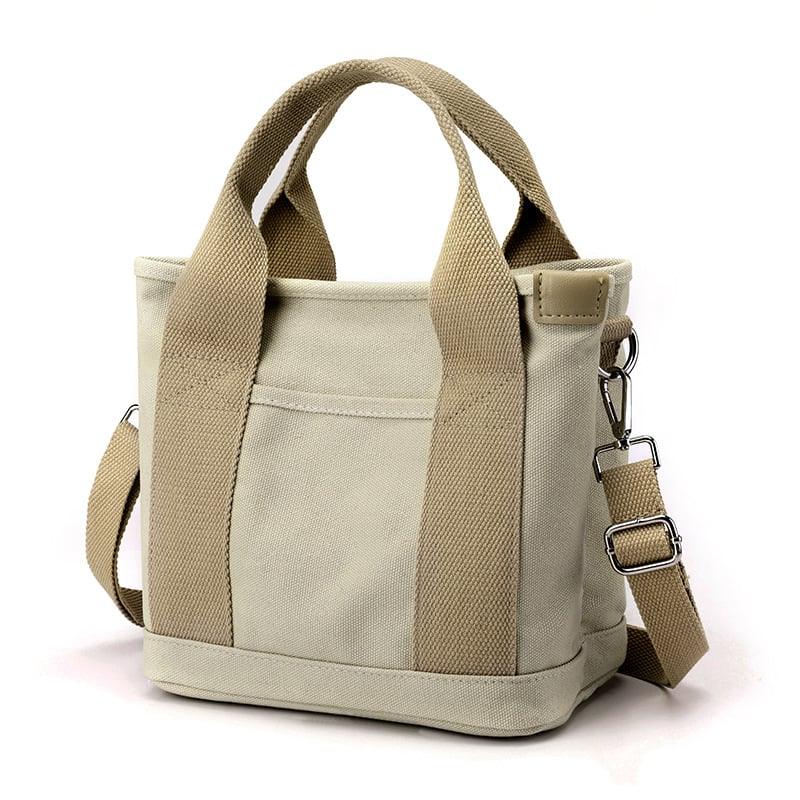 Sac à main en toile beige avec bandoulière réglable et poignées robustes. Design minimaliste, idéal pour un usage quotidien et tendance.