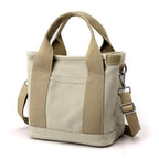Sac à main en toile beige avec bandoulière réglable et poignées robustes. Design minimaliste, idéal pour un usage quotidien et tendance.