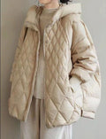 Veste matelassée beige pour femme, style décontracté, avec capuche, portée sur un pull beige. Mode automne-hiver, tendance et confortable.