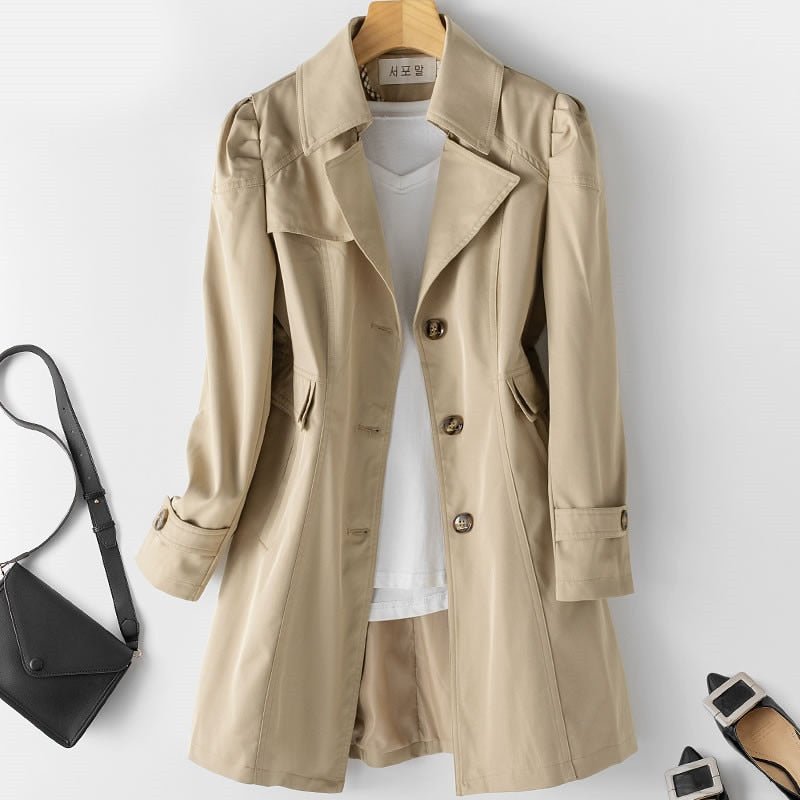 Trench-coat beige élégant pour femme, manches longues, boutons, avec t-shirt blanc et short assorti. Sac noir et sandales à talons inclus.