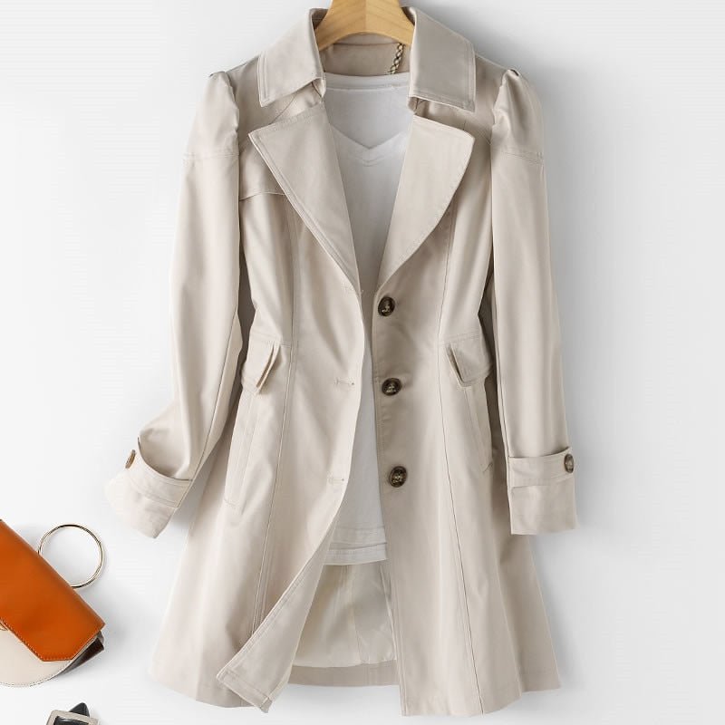Trench-coat beige élégant pour femme sur cintre, avec col à revers et boutons, parfait pour la mode automne-hiver.