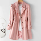 Manteau rose élégant pour femme sur cintre, avec chemise blanche en dessous, sac à main blanc à côté. Mode féminine, vêtements tendance.