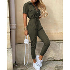 Combinaison kaki élégante pour femme, manches courtes, ceinture à la taille, associée à des baskets blanches et un sac à main blanc tendance.