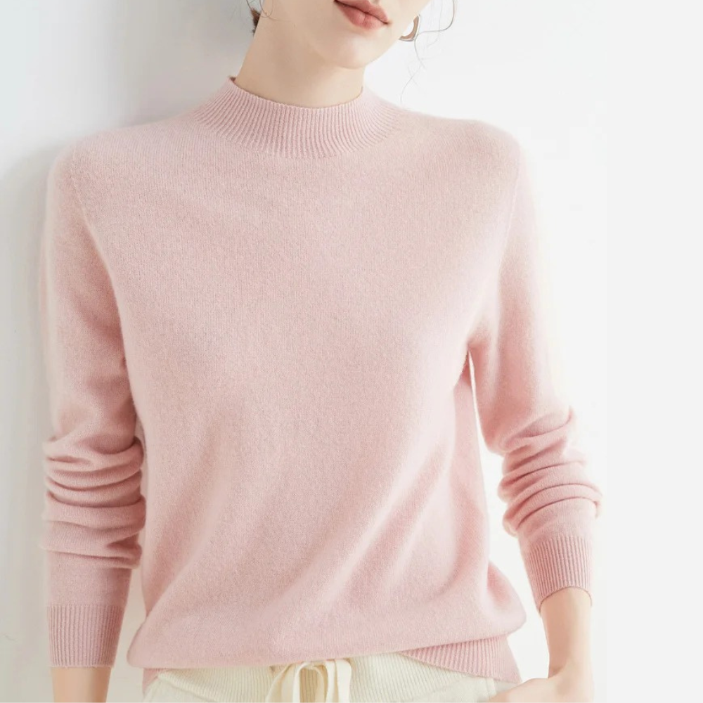 Femme portant un pull rose en cachemire, manches longues, col rond, style élégant et décontracté, mode automne-hiver, confort et douceur.