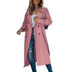 Femme portant un trench-coat rose élégant, jeans déchirés et sac à main noir. Mode automne, style urbain chic, tendance vestimentaire féminine.