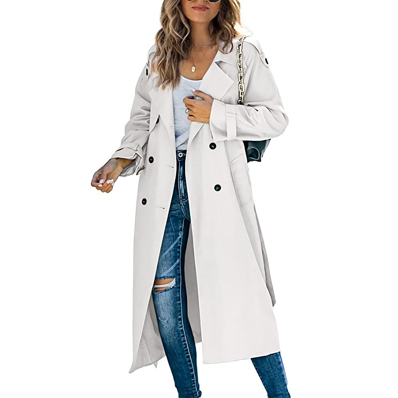 Femme portant un trench-coat blanc élégant, jeans déchirés et sac à main noir. Mode automne, style urbain chic, tendance vestimentaire féminine.