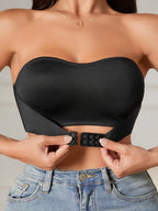 Femme portant un bustier noir sans bretelles, ajustant la fermeture avant. Mode féminine, top élégant, style moderne, jeans décontracté.