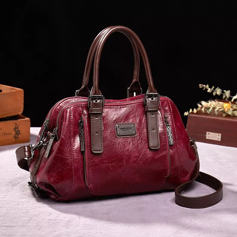 Sac à main en cuir rouge bordeaux avec poignées marron, design élégant, idéal pour la mode féminine. Accessoire tendance et chic.