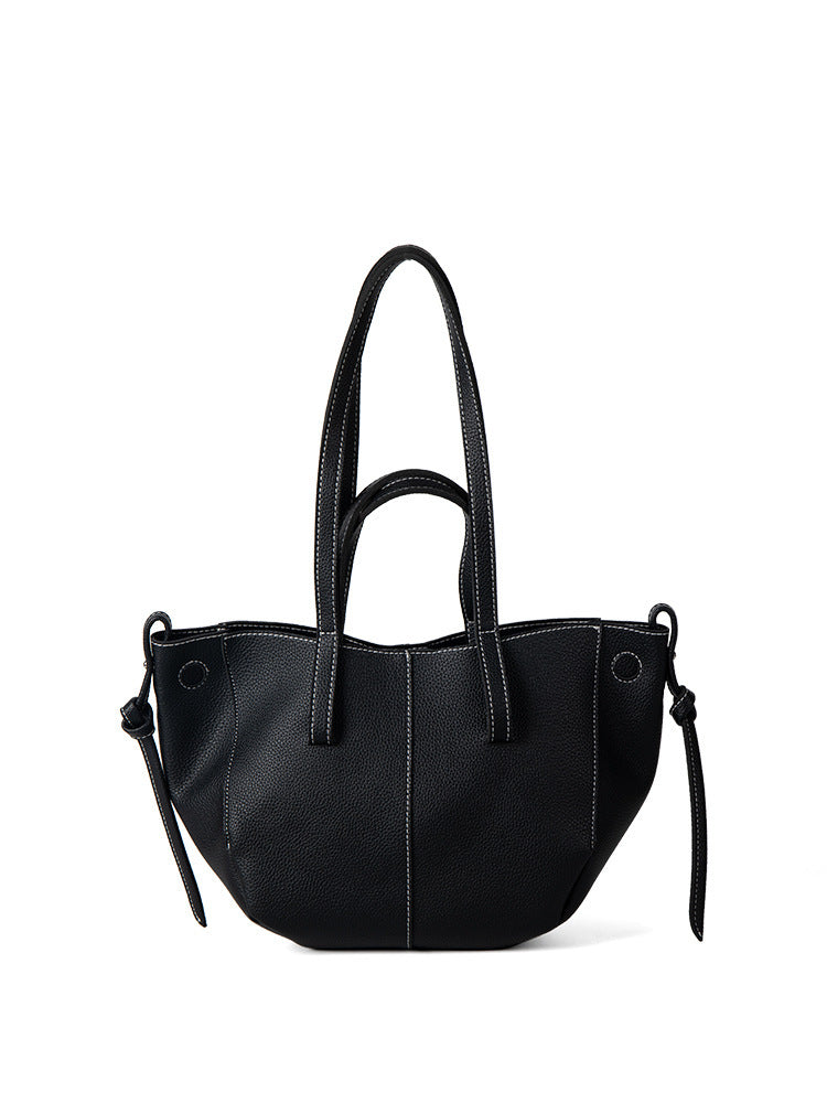 Sac à main noir en cuir avec coutures blanches, poignées doubles et nœuds latéraux. Accessoire mode élégant et tendance pour femme.