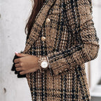 Femme portant une veste en tweed à carreaux marron et noir, accessoirisée d'une montre dorée élégante. Mode automne chic et tendance.