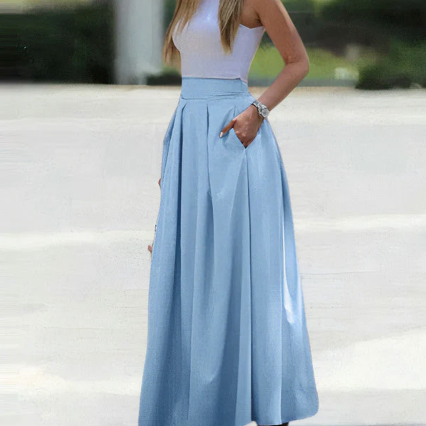 Robe longue bleue élégante avec poches, portée par une femme en extérieur. Mode féminine chic, tenue d'été tendance, style décontracté.