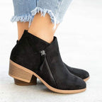 Bottines noires en daim avec talon carré, fermeture éclair latérale, portées avec un jean effiloché. Chaussures tendance automne-hiver pour femmes.