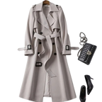 Trench-coat beige élégant avec ceinture, sac à main noir en cuir matelassé et escarpins noirs. Mode automne chic, tenue féminine sophistiquée.
