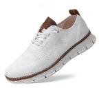 Chaussure de sport blanche en maille respirante avec semelle antidérapante, lacets blancs et détails marron, idéale pour la marche et le confort.
