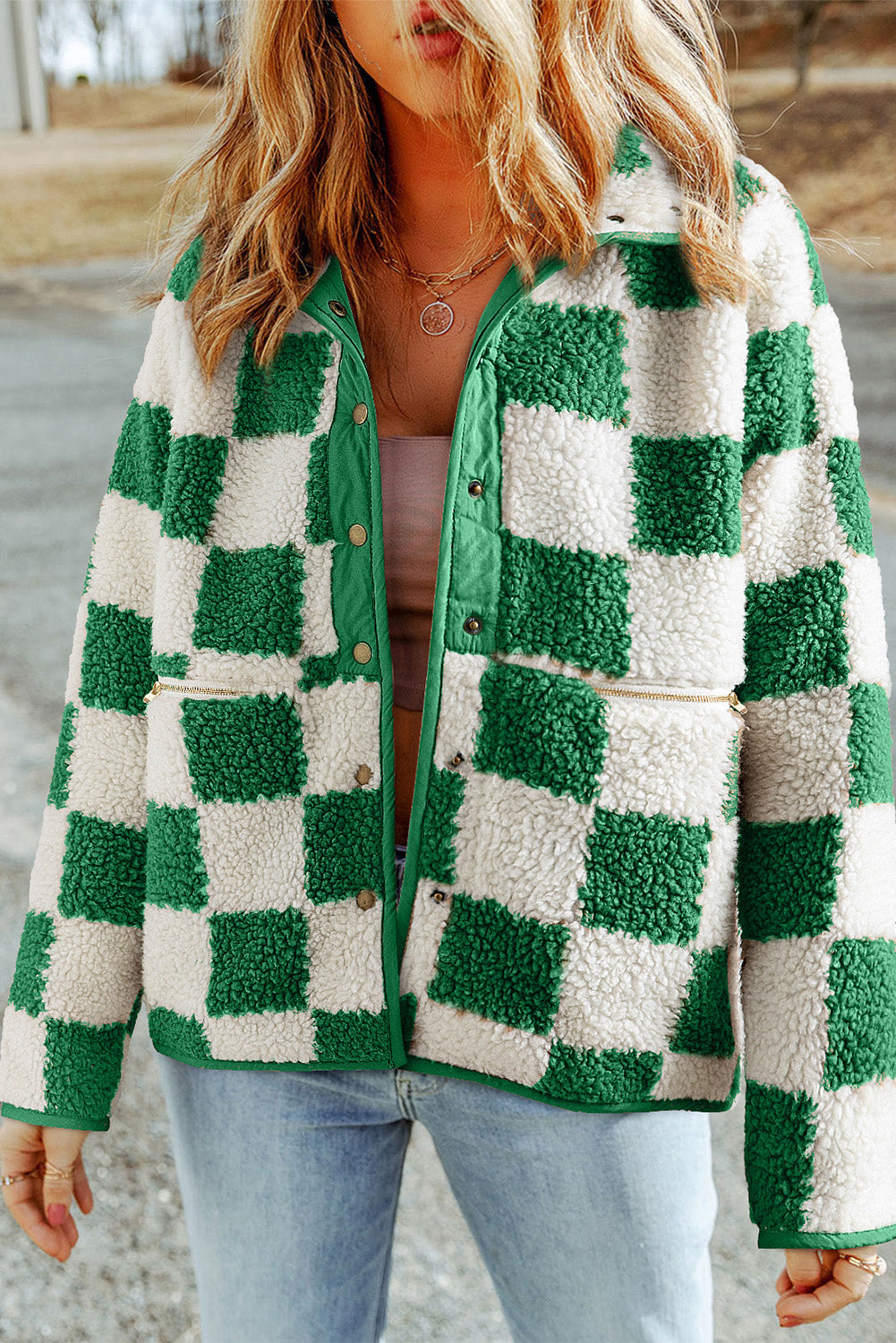 Veste à carreaux verts et blancs en laine bouclée, portée par une femme, style décontracté, mode automne-hiver, tendance streetwear.