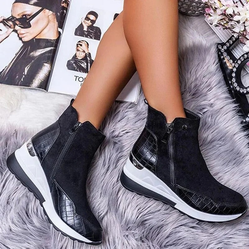 Bottes noires en cuir texturé sur tapis en fourrure grise, avec magazines de mode en arrière-plan. Chaussures tendance, style moderne et élégant.