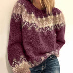 Pull en laine épaisse bordeaux avec motifs géométriques blancs et beiges, porté par une femme. Mode automne-hiver, style décontracté et tendance.