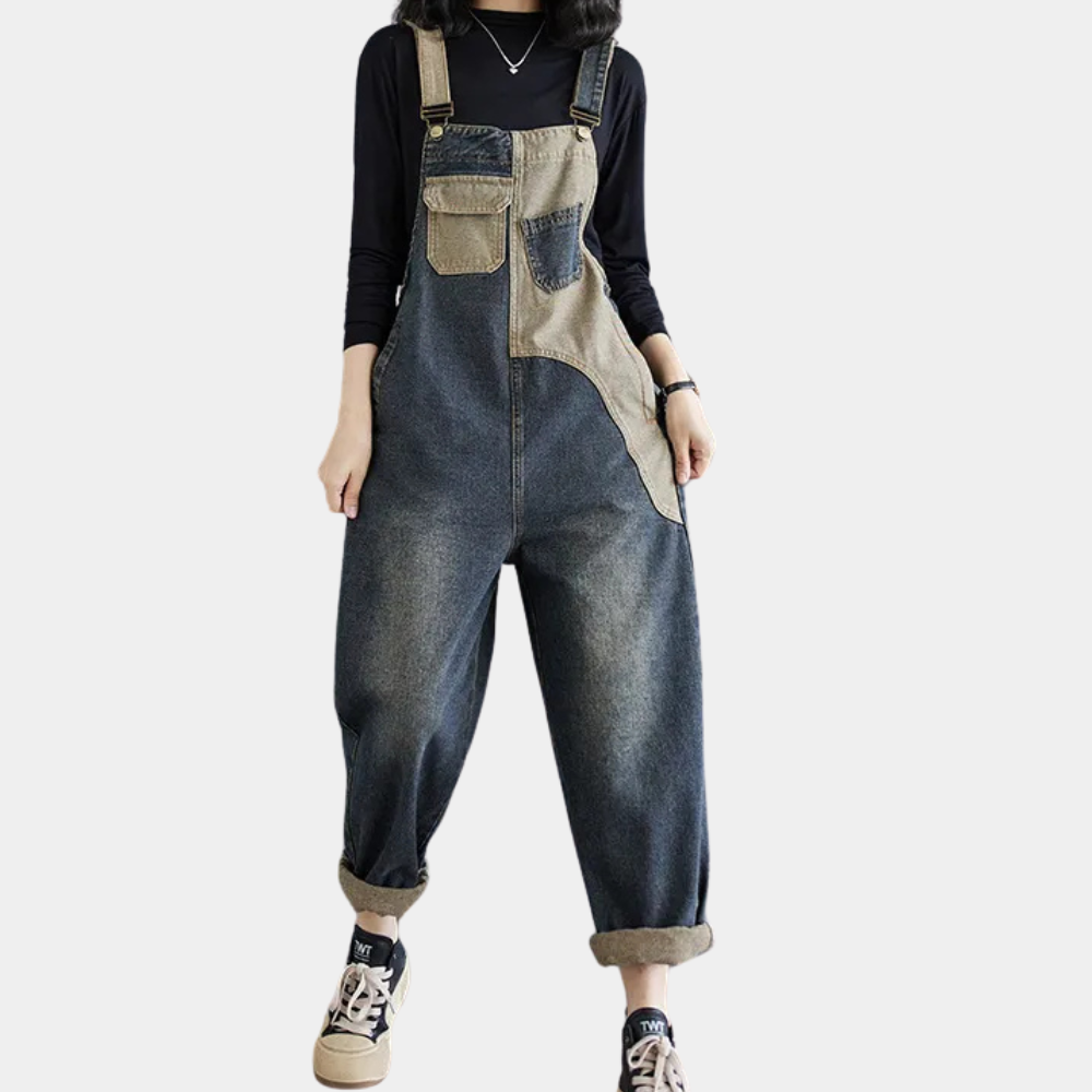 Salopette en jean décontractée pour femme, style patchwork, avec poches, portée avec un haut noir à manches longues et baskets.