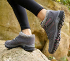 Chaussures de randonnée grises pour femme avec semelle antidérapante, portées sur un rocher. Idéales pour trekking et activités en plein air.