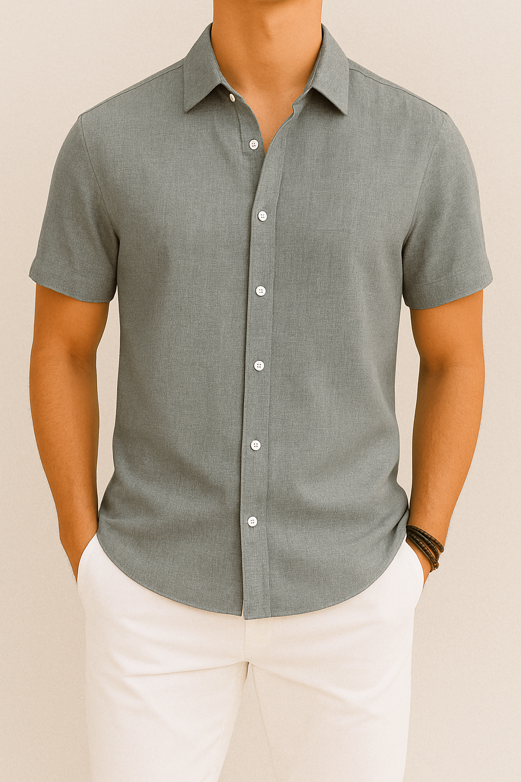 Chemise grise à manches courtes pour homme, élégante et moderne, avec boutons blancs, portée avec un pantalon blanc. Mode masculine chic et décontractée.