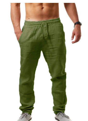 Homme portant un pantalon vert en lin, taille élastique, mains dans les poches, torse nu, montre noire, baskets grises. Mode décontractée masculine.