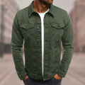 Homme portant une veste en jean verte, style décontracté, sur un t-shirt blanc, dans un environnement urbain flou. Mode masculine tendance.