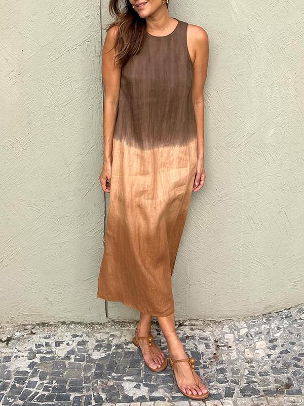 Robe longue dégradée marron et beige, sans manches, portée par une femme. Mode estivale élégante, sandales plates, mur texturé en arrière-plan.