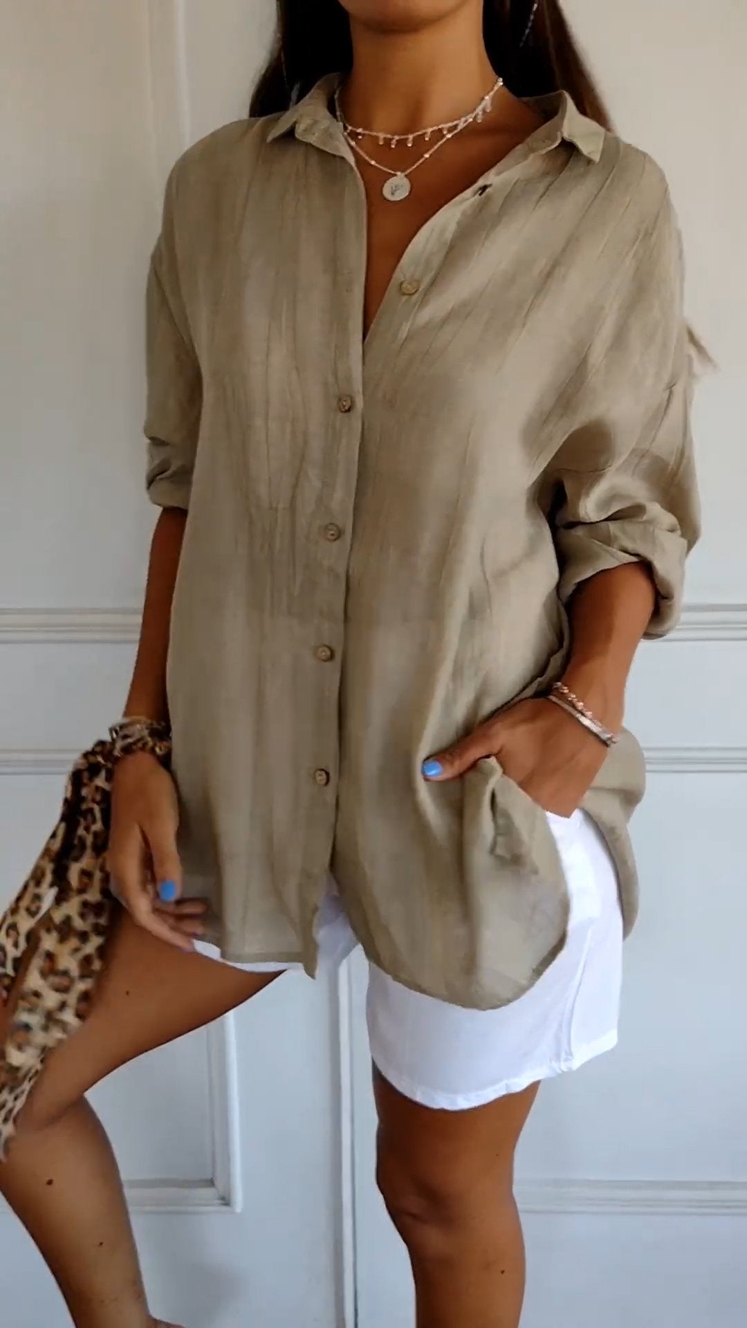 Chemise beige en lin, manches retroussées, portée avec short blanc. Style décontracté, mode estivale, tendance féminine, accessoires léopard.