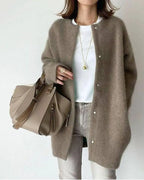 Femme portant un manteau en laine marron, t-shirt blanc, jean gris, et sac à main beige. Mode automne, style décontracté chic.