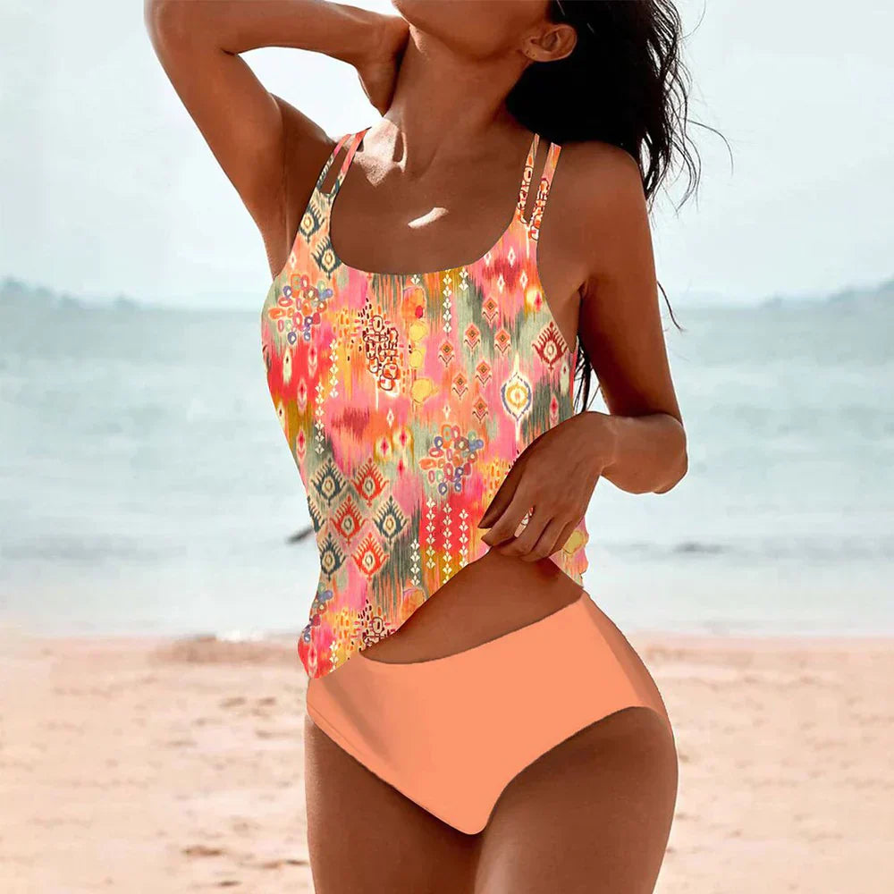 Femme en maillot de bain coloré sur plage, motif ethnique, mer en arrière-plan, ciel clair. Mode plage, été, vacances, style tendance.