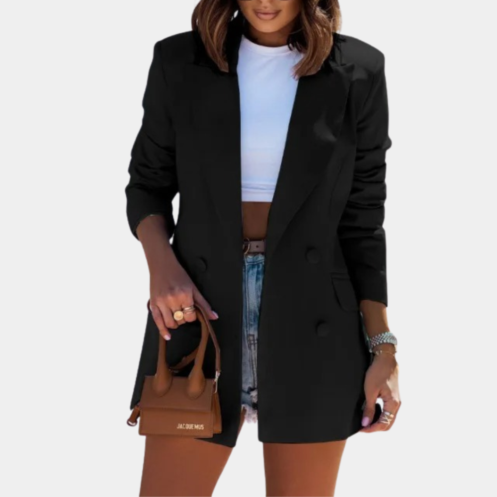 Femme en blazer noir élégant, t-shirt blanc, short en jean, tenant un mini sac à main marron. Mode chic, tendance, style urbain.