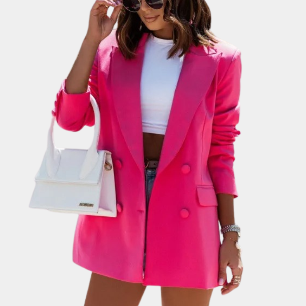 Femme portant un blazer rose vif, t-shirt blanc, short en jean, lunettes de soleil et sac à main blanc. Mode tendance, style chic et moderne.