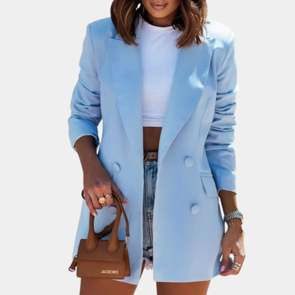 Femme portant un blazer bleu clair, t-shirt blanc, short en jean, tenant un sac à main marron. Mode élégante, tenue décontractée chic.