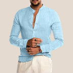 Chemise en lin bleu clair pour homme, col mao, manches longues, boutons, style décontracté, portée avec un pantalon beige. Mode masculine élégante.