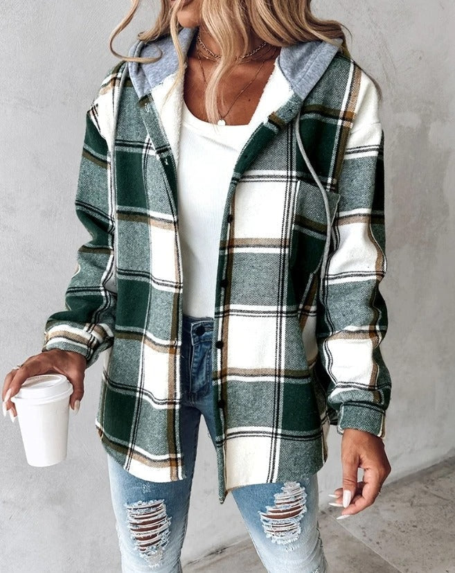 Femme portant une chemise à carreaux vert et blanc, tenue décontractée avec jean déchiré, tenant un gobelet à café. Mode automne tendance.