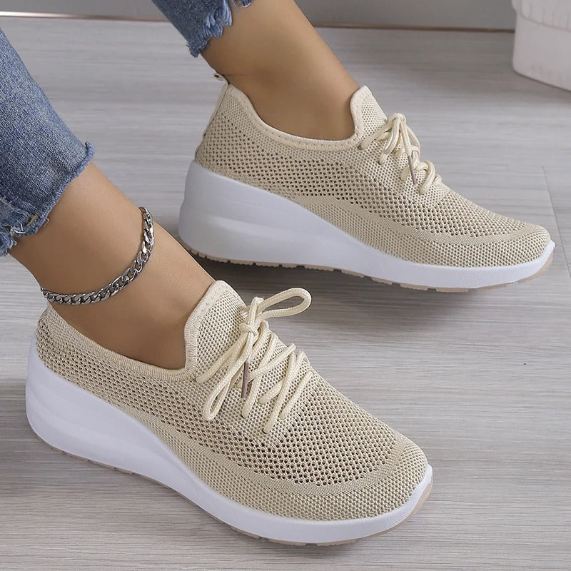 Baskets beiges en maille respirante pour femme, semelle épaisse blanche, style décontracté, mode, confort, portées avec un jean et bracelet chaîne.
