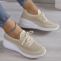 Baskets beiges en maille respirante pour femme, semelle épaisse blanche, style décontracté, mode, confort, portées avec un jean et bracelet chaîne.